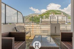 a balcony with chairs and a view of a mountain at R'Apparts T3 Bastille Horizon in Grenoble