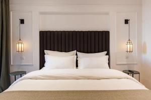 Chimera Apartments & Suites في مراكش: غرفة نوم بسرير ابيض كبير ومصباحين