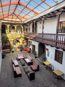 un patio interior con mesas y sillas en un edificio en Hotel Cusco Plaza Saphi, en Cusco