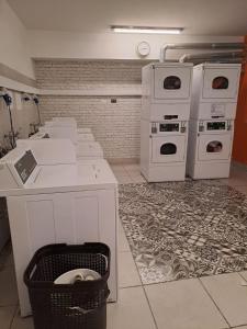 a kitchen with white appliances and a trash can at Lindo departamento equipado (Cercano a Terminal Sur) in Santiago