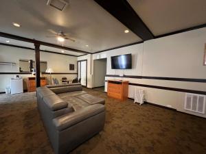 sala de estar con sofá y TV de pantalla plana en Wells Gray Inn, en Clearwater