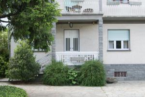 a white house with a white door and a balcony at La Casa di Bianca in SantʼAmbrogio di Torino