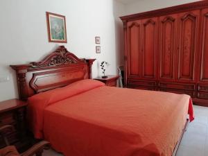 nonna Tomasina في بورتو بوزو: غرفة نوم بسرير احمر وخزانة خشبية