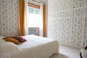 ein Schlafzimmer mit einem weißen Bett und einem Fenster in der Unterkunft La Casa di Bianca in SantʼAmbrogio di Torino