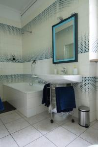 ein Badezimmer mit einer Badewanne, einem Waschbecken und einem Spiegel in der Unterkunft La Casa di Bianca in SantʼAmbrogio di Torino