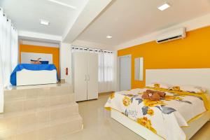 Schlafzimmer mit einem Bett und orangefarbenen Wänden in der Unterkunft Sun Express Hotel in Pueblo Bávaro