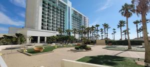a large building with palm trees in front of it at Sapphire 1706 in South Padre Island