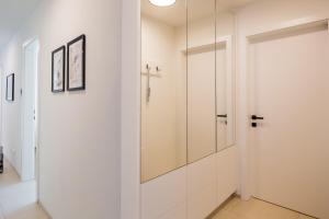 uma casa de banho branca com uma porta de duche envidraçada em Moderne Wohnung mit Terrasse em Innsbruck