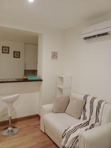 sala de estar con sofá blanco y taburete en Excelente Monoambiente Monito 15 en La Plata