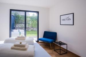 a bedroom with two beds and a blue chair at Moderne Wohnung mit Terrasse in Innsbruck