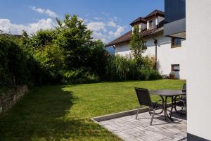 een patio met een tafel en stoelen in een tuin bij Moderne Wohnung mit Terrasse in Innsbruck