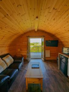 een woonkamer met een bank en een tafel bij Pond View Pod 2 with Private Hot Tub -Pet Friendly- Fife - Loch Leven - Lomond Hills in Kelty