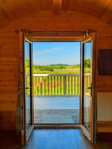 an open door in a cabin with a view of a deck at Pond View Pod 2 with Private Hot Tub - Fife - Loch Leven - Lomond Hills in Kelty