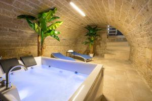 a bathroom with a bath tub in a brick wall at 2 Love rooms in Corato
