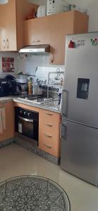 uma cozinha com um fogão e um frigorífico em Marina golf em Asilah