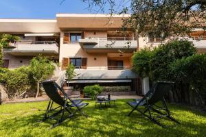 Dos sillas y una mesa frente a un edificio. en Villa Albachiara, en Catania