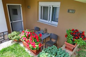 un patio con flores, mesa y sillas en Fou's apartment en Nafpaktos