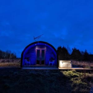 uma pequena casa cúpula com duas cadeiras à noite em Pond View Pod 3 With Private Hot Tub - Pet Friendly -Fife - Loch Leven - Lomond Hills em Kelty