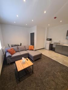 ein Wohnzimmer mit einem Sofa und einem Tisch in der Unterkunft Homestay by BIC Oates 4 in Dewsbury