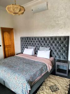 a bedroom with a large bed with a large headboard at Villa Nathalie Marrakech in Marrakesh