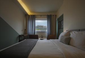 a bedroom with a large bed and a window at Elite Ermou Suites in Athens