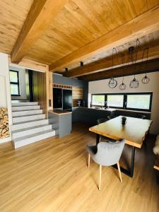 cocina y sala de estar con techo de madera y mesa en CHALETY MÝTO POD ĎUMBIEROM, en Mýto pod Ďumbierom