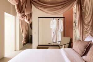 a bedroom with a bed and a window with a mannequin at Niove Suites Milos in Plaka Milou