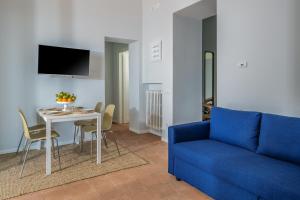 ein Wohnzimmer mit einem blauen Sofa und einem Tisch in der Unterkunft Villa Chiara in Vico Equense