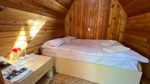 ein Schlafzimmer mit einem Bett in einer Holzhütte in der Unterkunft Birchy Island in Kerben