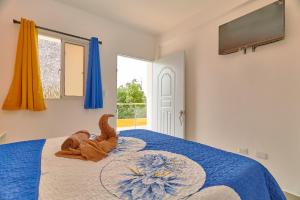 a bedroom with a bed with a blue comforter at Sun Express Hotel in Pueblo Bavaro