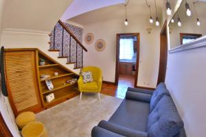 sala de estar con sofá azul y silla amarilla en Apartamentos Francisco Martins, en Vila Franca do Campo