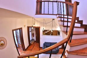 a staircase in a house with a blue chair at Apartamentos Francisco Martins in Vila Franca do Campo