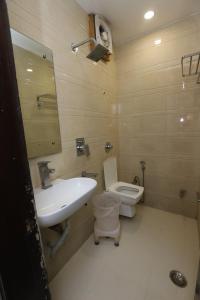 a bathroom with a white sink and a toilet at Hotel Emporio Dx - New Delhi Railway Station - Paharganj in New Delhi