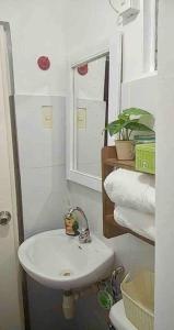 Baño blanco con lavabo y espejo en Entire Unit Fully Air-conditioned with Hi-Speed WiFi, en Mabalacat