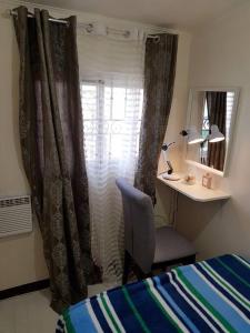 een slaapkamer met een bed, een bureau en een raam bij Entire Unit Fully Air-conditioned with Hi-Speed WiFi in Mabalacat