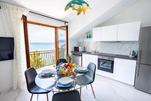 a kitchen and dining room with a table and chairs at Lux Gradac in Gradac