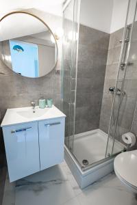 uma casa de banho com um chuveiro, um lavatório e um espelho. em Lux Gradac em Gradac