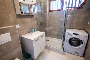 a bathroom with a washing machine and a washer at Lux Gradac in Gradac