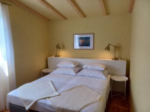 1 dormitorio con 1 cama con sábanas y almohadas blancas en Unique residence with garden and sea view en Split