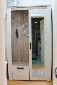 a wooden cabinet with a mirror in a bathroom at Flexible SelfCheckIns 52 - Zagreb - Parking - Loggia in Zagreb