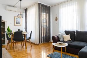 een woonkamer met een bank en een tafel bij Flexible SelfCheckIns 52 - Zagreb - Parking - Loggia in Zagreb