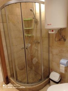 a shower with a glass door in a bathroom at Студио за гости БОРИСА in Kranevo