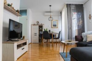 a living room with a television and a table at Flexible SelfCheckIns 52 - Zagreb - Parking - Loggia in Zagreb