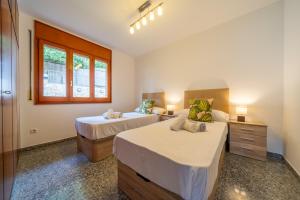 - une chambre avec 2 lits et une fenêtre dans l'établissement Villa Santa Cristina Lux, Ideal Familias, frente al Mar - Cala Treumal, à Blanes