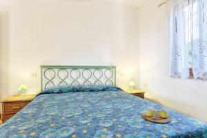 a bedroom with a blue bed with two cups on it at I SALICI in Capoliveri