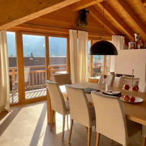 comedor con mesa y sillas y balcón en Chalet Bergliebe zentral mit Bergblick en Seefeld in Tirol