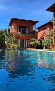 une villa avec une piscine en face d'une maison dans l'établissement Pousada Flor de Lena Icaraizinho - Suíte Jasmim, à Icaraí
