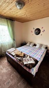 sypialnia z łóżkiem i drewnianym sufitem w obiekcie Ny to Abzatc w Sławsku