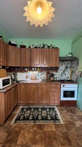 a kitchen with wooden cabinets and a chandelier at Ny to Abzatc in Slavske