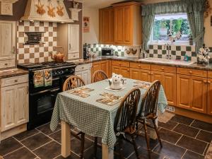 a kitchen with a table with a table cloth on it at The Moorings in Garlieston
